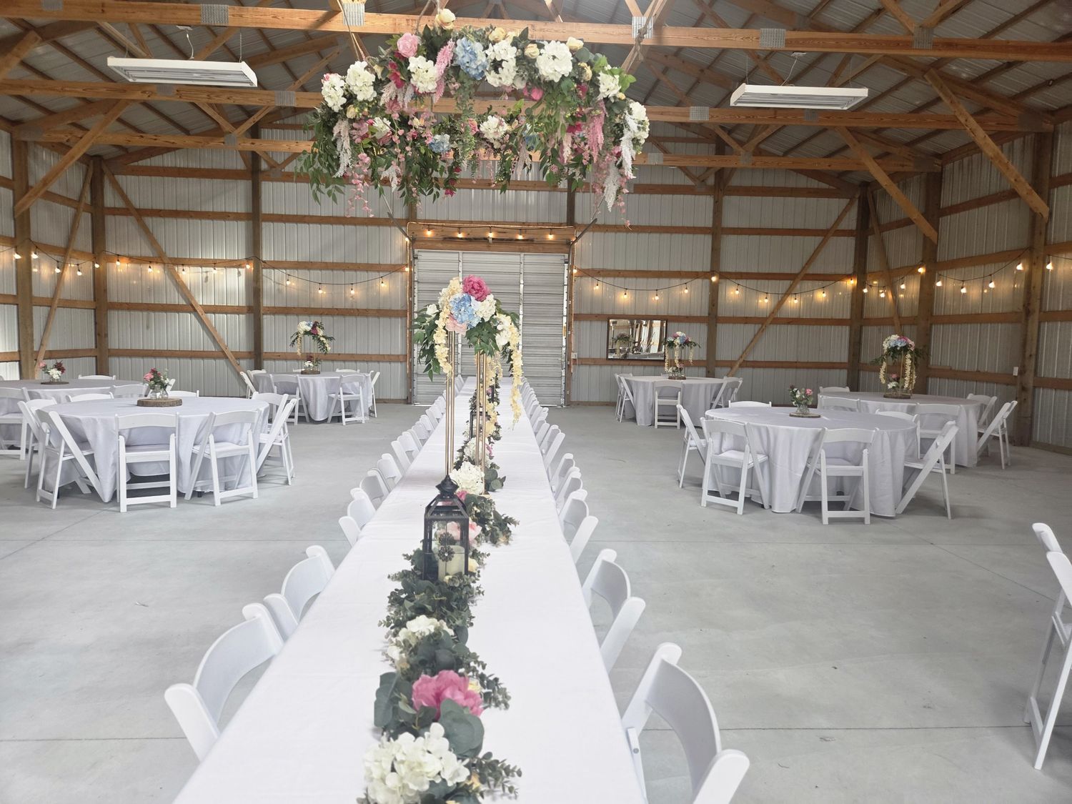 A hanging floral hoop, table garland and tall centerpieces for a barn reception