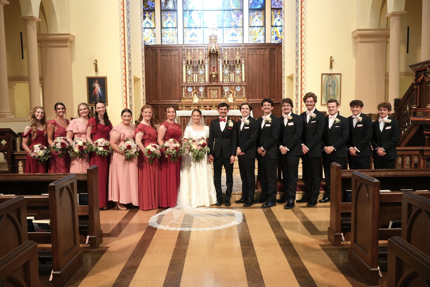 The bridal party before the altar, every bridesmaid carrying roses