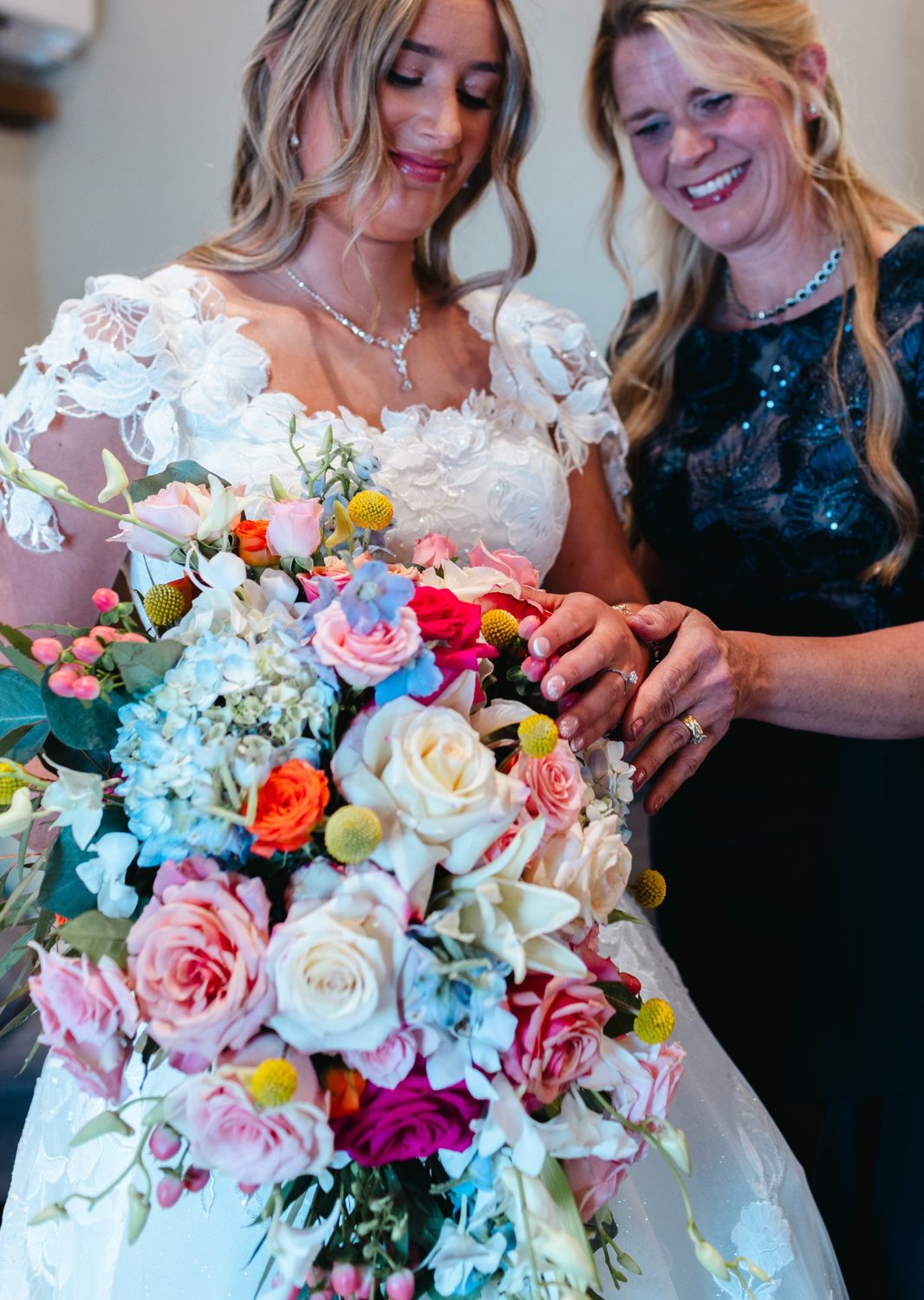 A bright cascade bouquet of garden roses, hydrangea, delphinium and craspedia