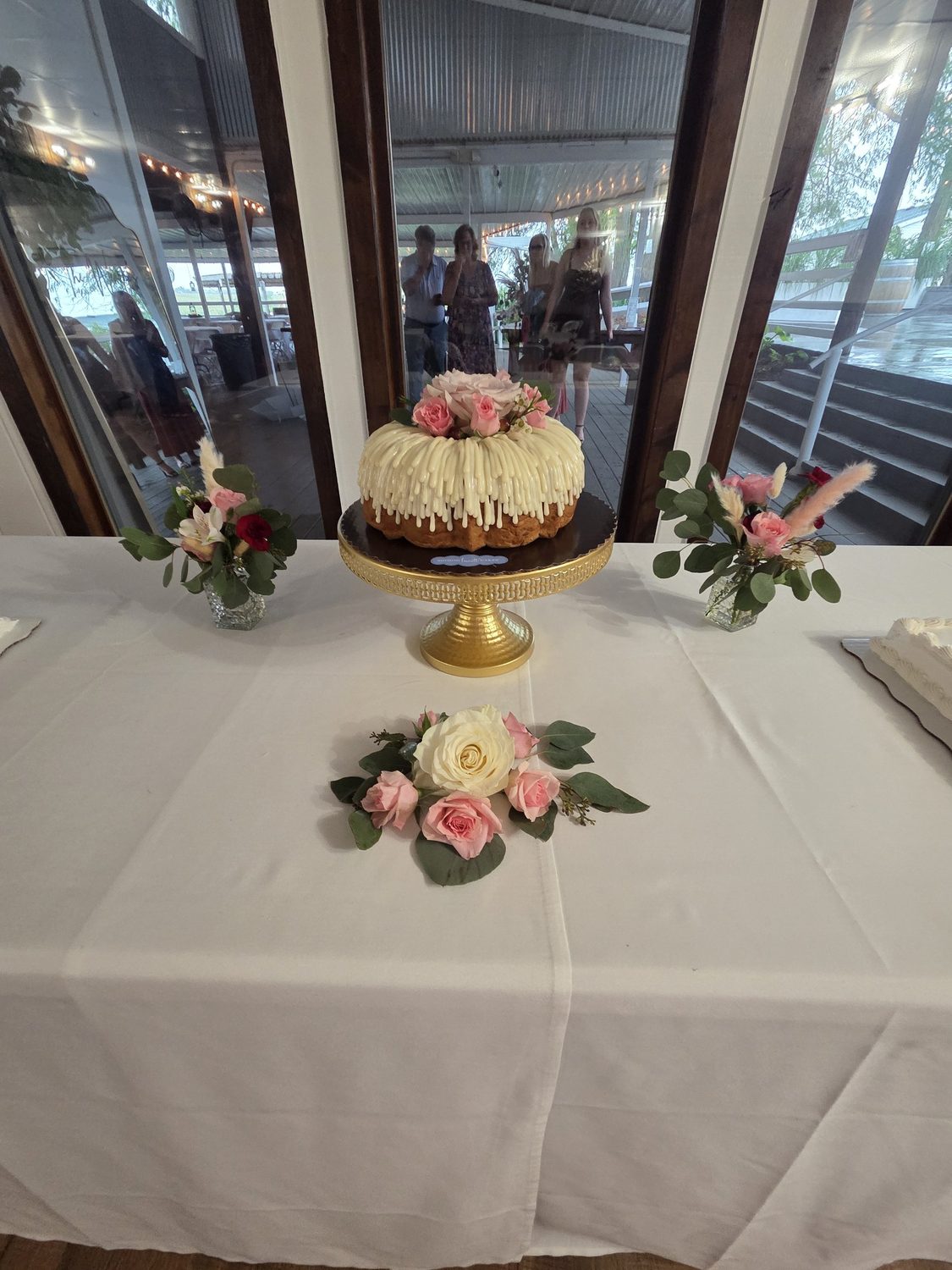 Rose bud vases and a rose-and-eucalyptus accent around the cake