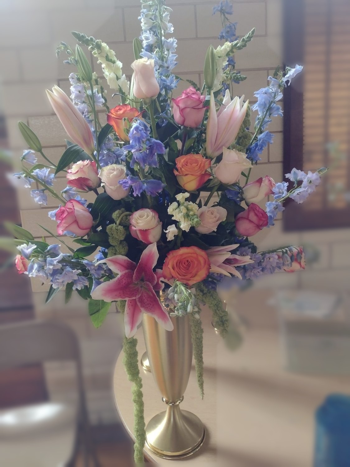Delphinium, stargazer lilies, roses and snapdragons with trailing amaranthus