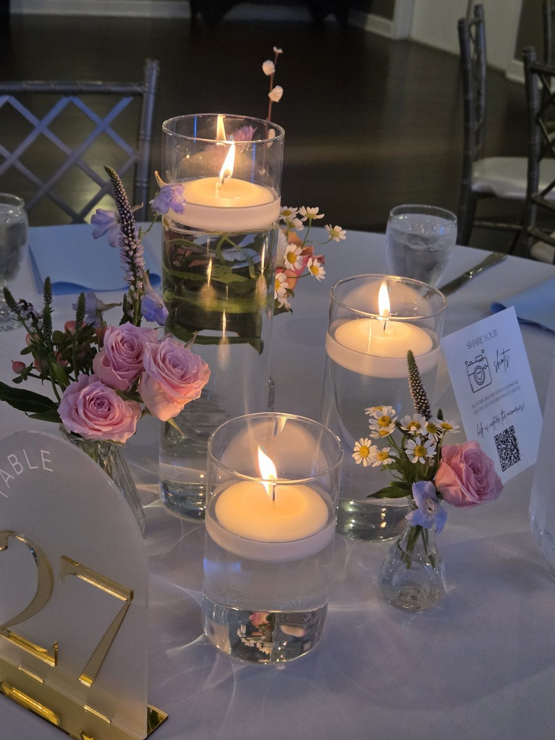 Floating candles with bud vases of spray roses, chamomile, veronica and delphinium
