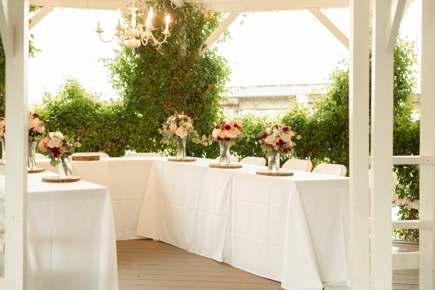 Rose centerpieces with eucalyptus on wood rounds for a garden reception