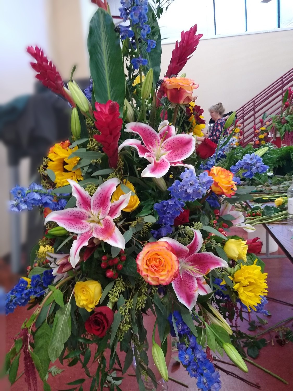A bold arrangement of red ginger, stargazer lilies, sunflowers, roses and delphinium