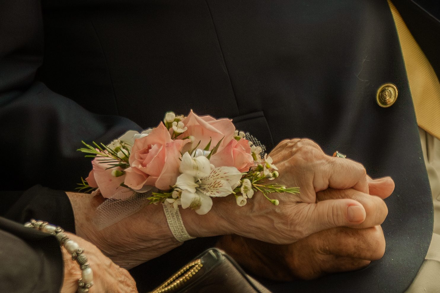 A wrist corsage of spray roses, alstroemeria and waxflower for the grandmother