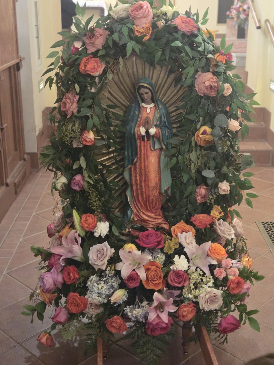 A feast day tribute of roses, lilies and hydrangea for Our Lady of Guadalupe