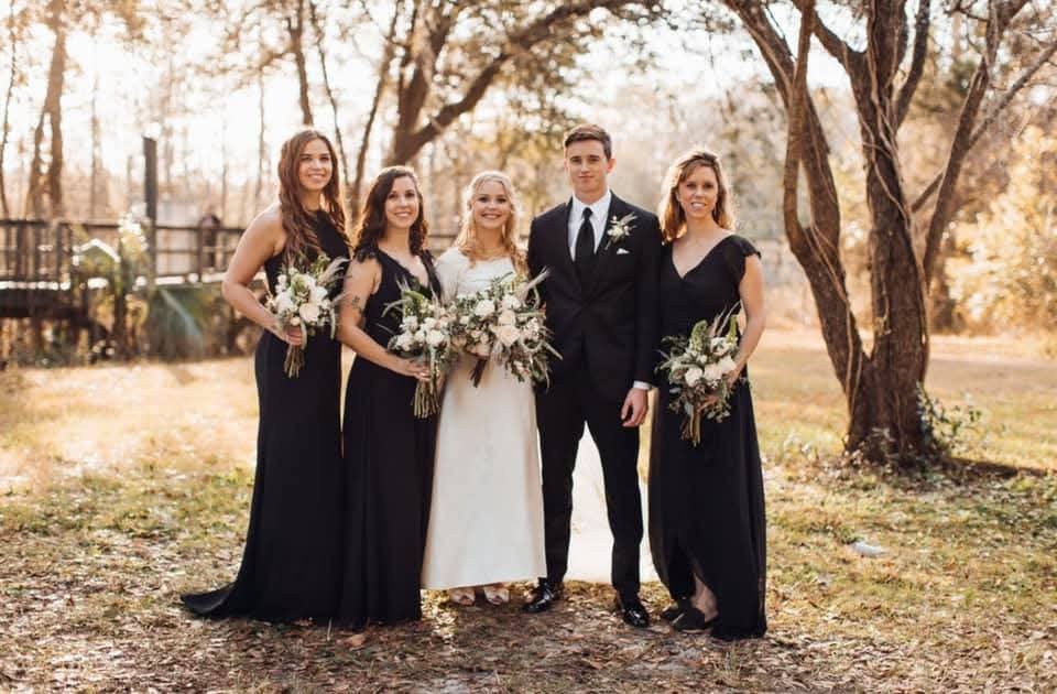 Ivory bouquets set against black bridesmaid gowns