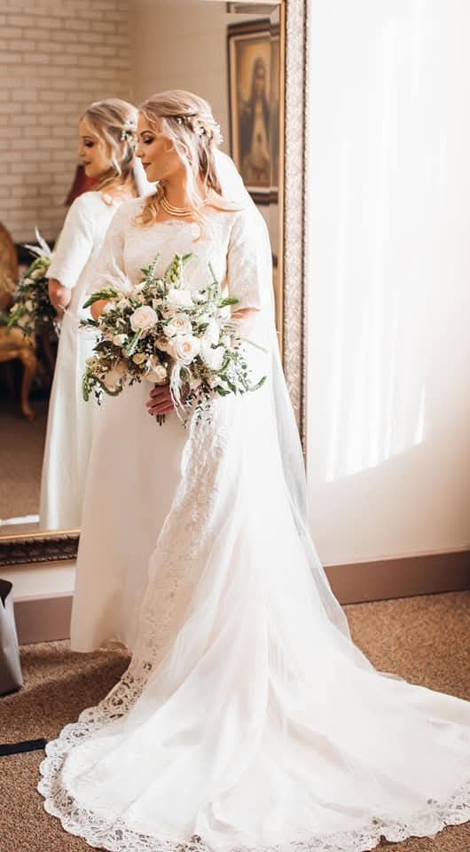 A loose, garden-style bridal bouquet of white roses, snapdragons and trailing greens