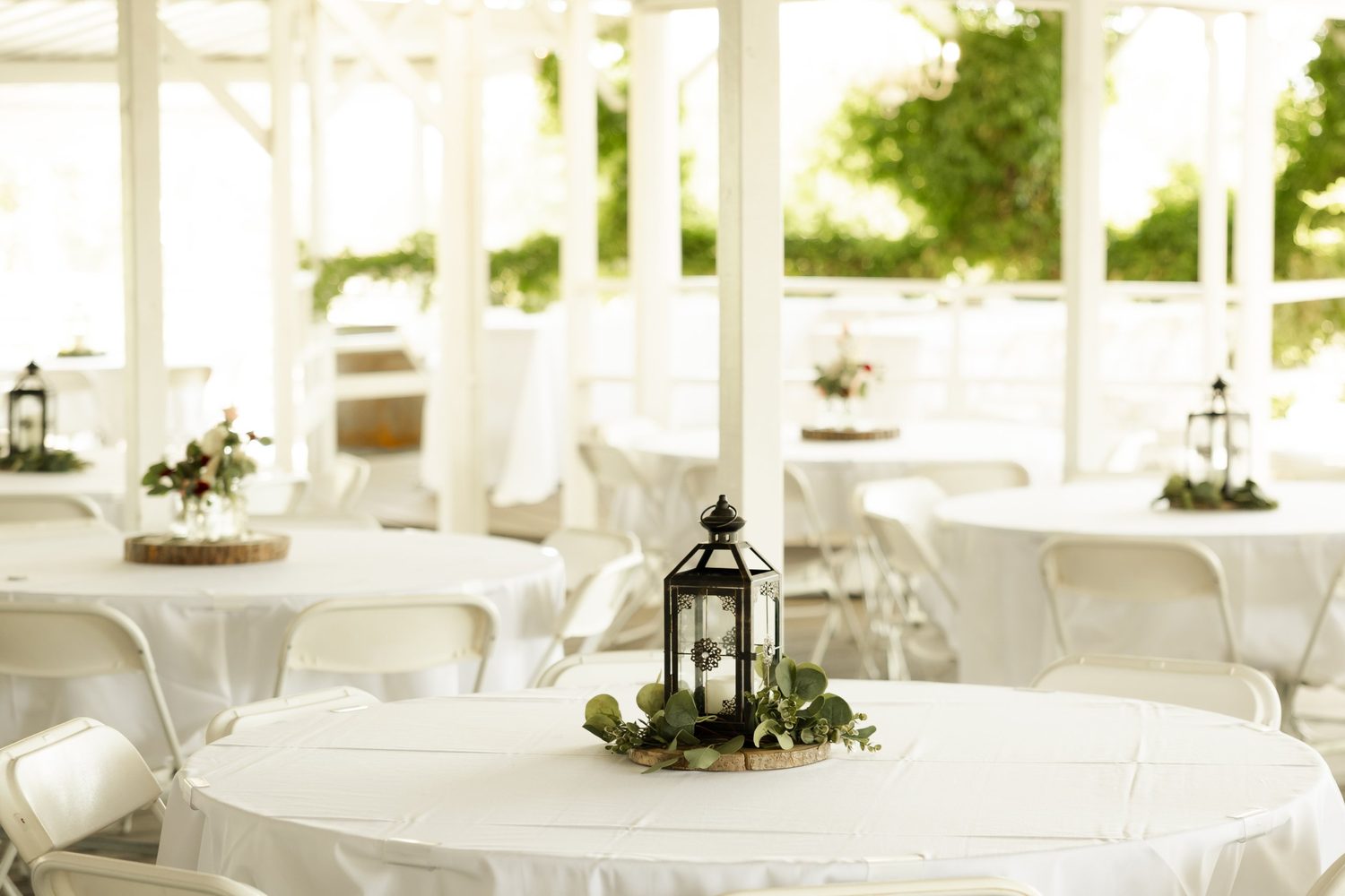 Lantern centerpieces with eucalyptus for an open-air reception