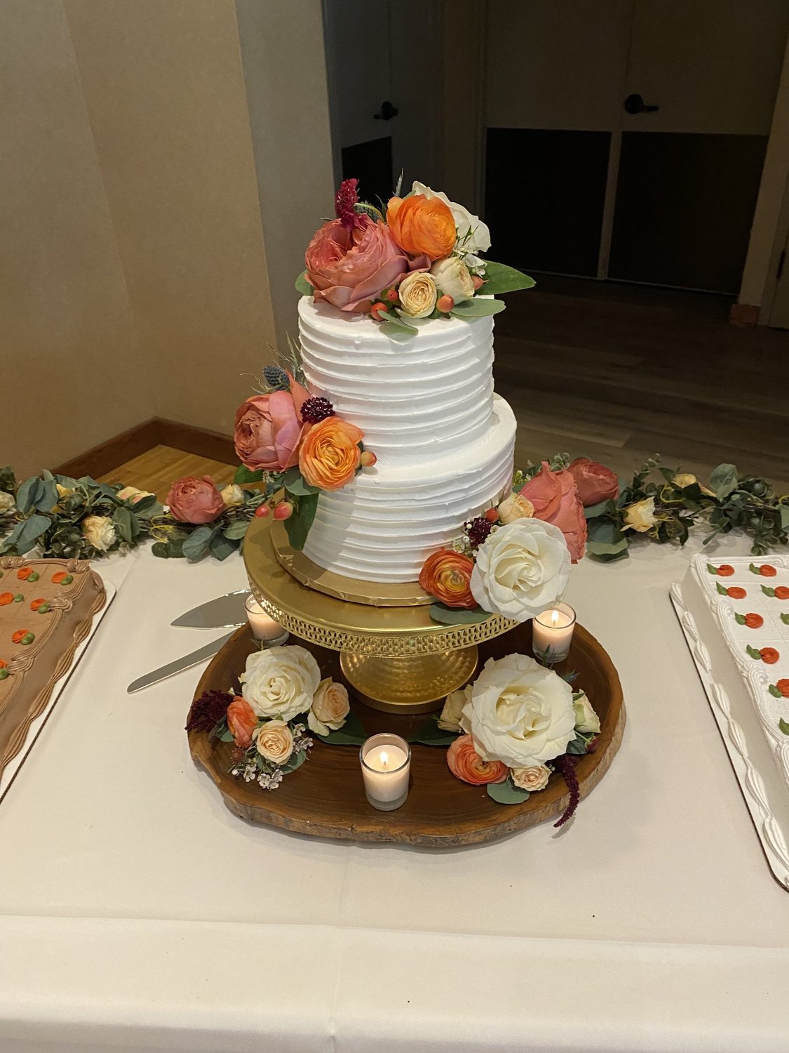Garden roses, ranunculus and scabiosa cascading down the wedding cake