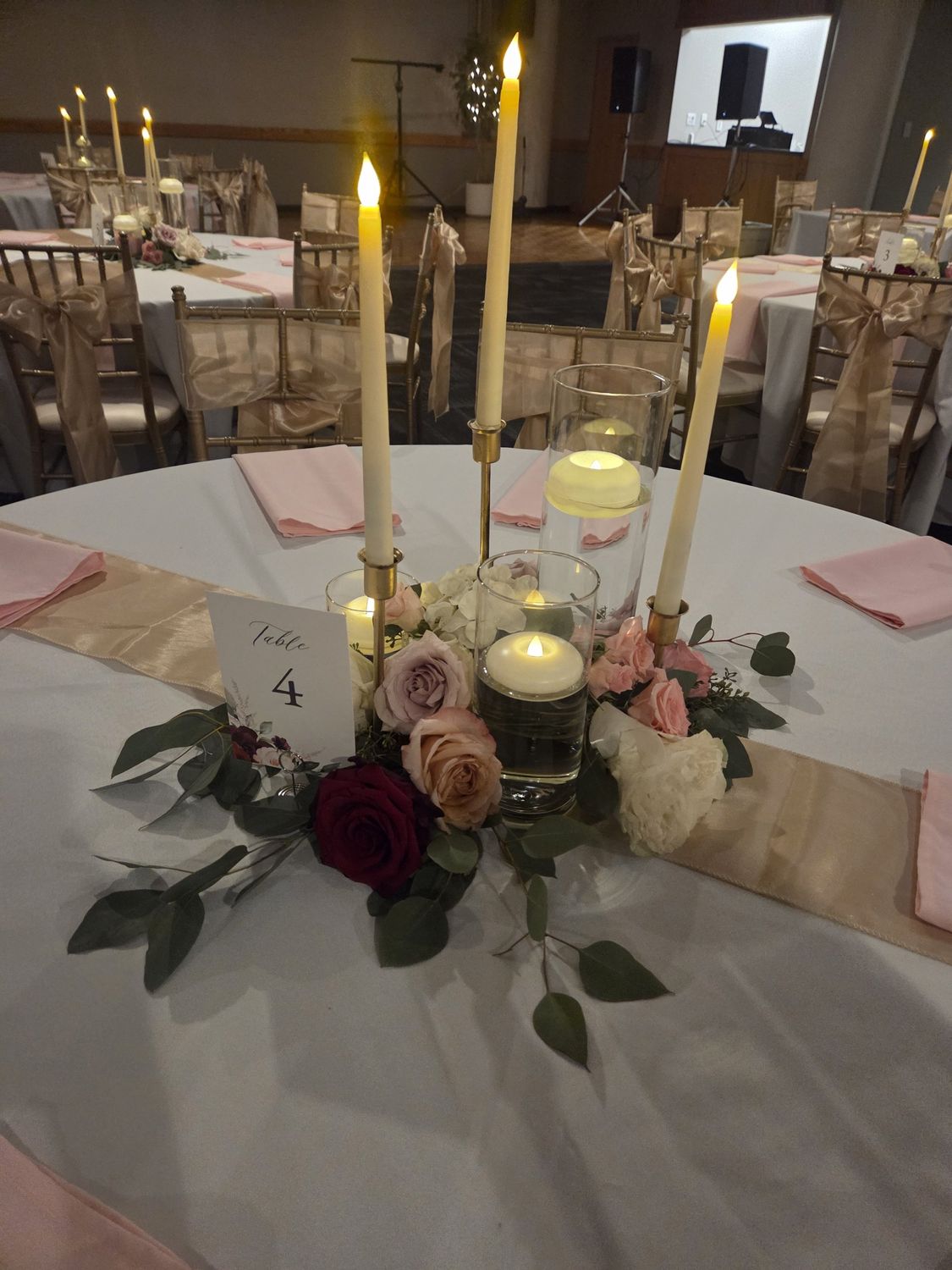 A candlelit reception centerpiece of garden roses and eucalyptus
