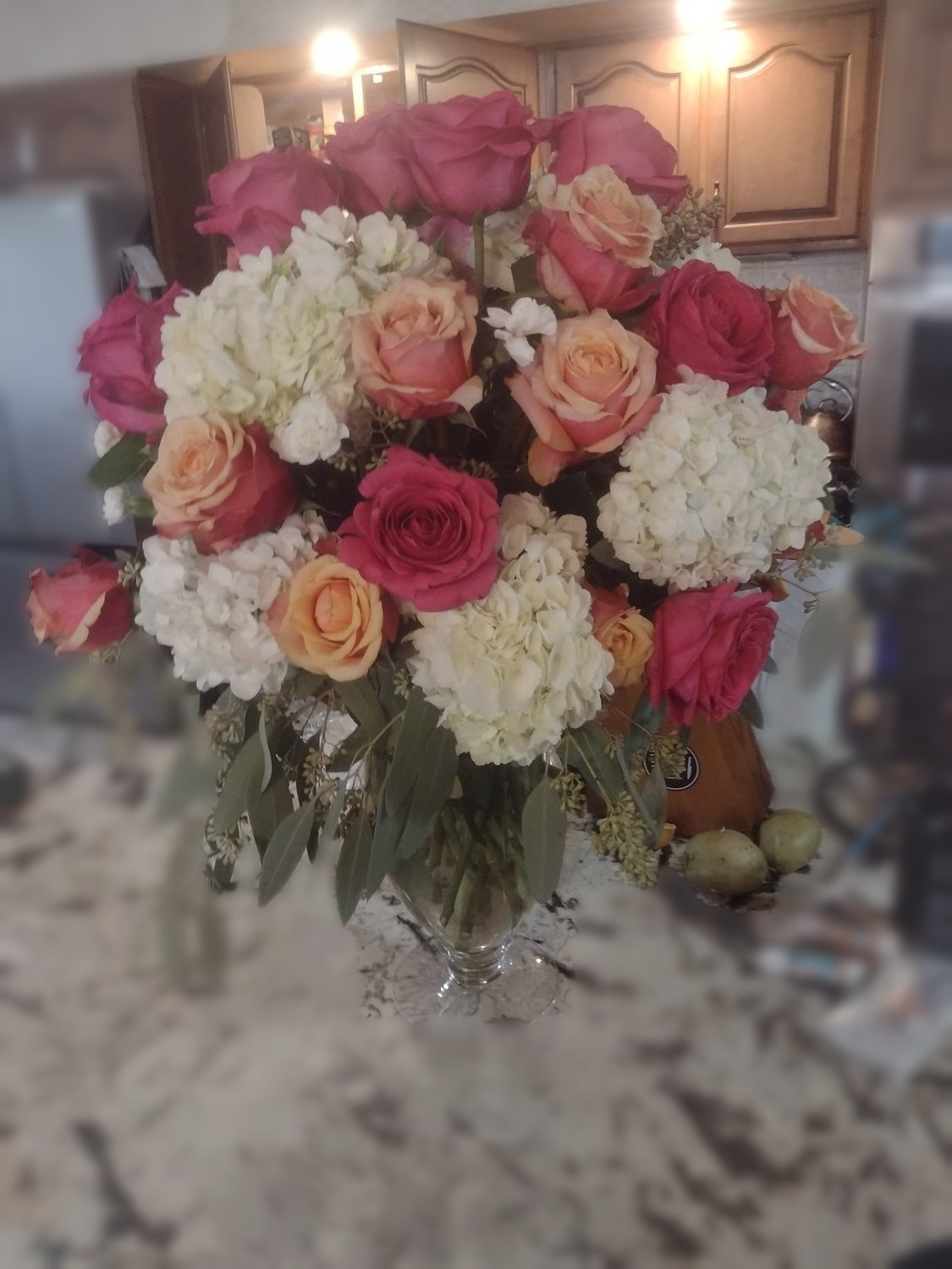 Hot pink and peach roses with white hydrangea and seeded eucalyptus