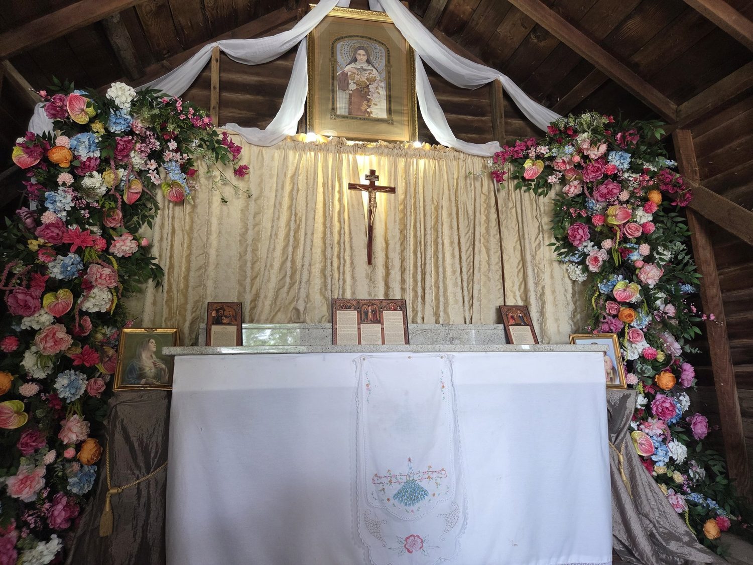 Floral cascades framing a chapel altar beneath St. Thérèse