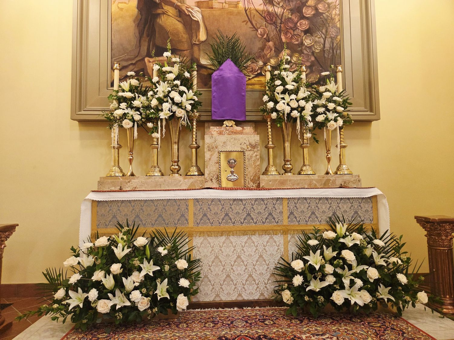White lilies and roses flanking the altar